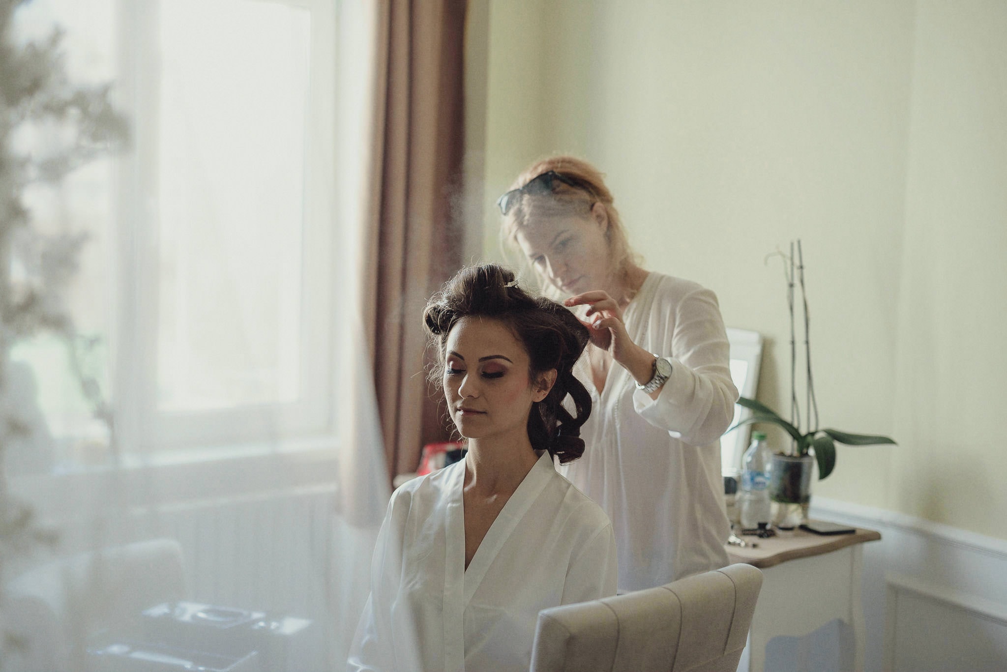bride getting her hair and makeup done moments before the wedding