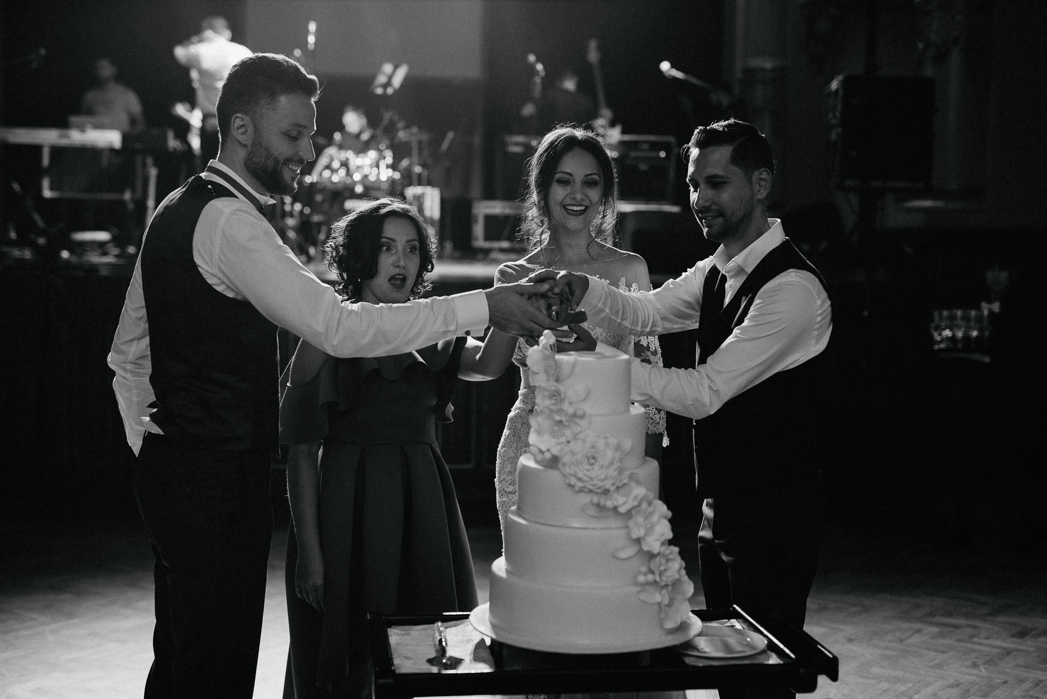 bride and groom cut their wedding cake together with their godparents