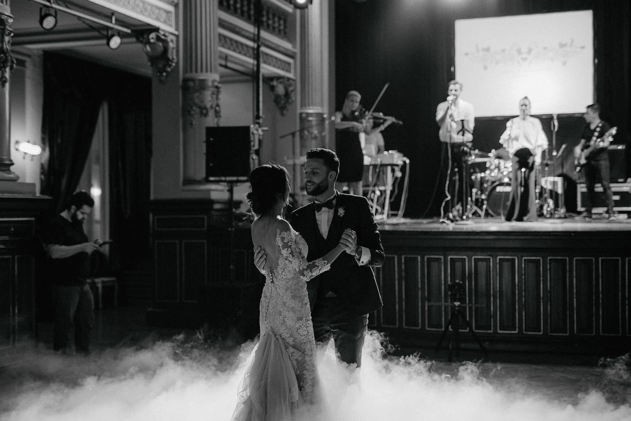 bride and groom dance together to a song performed by a live band