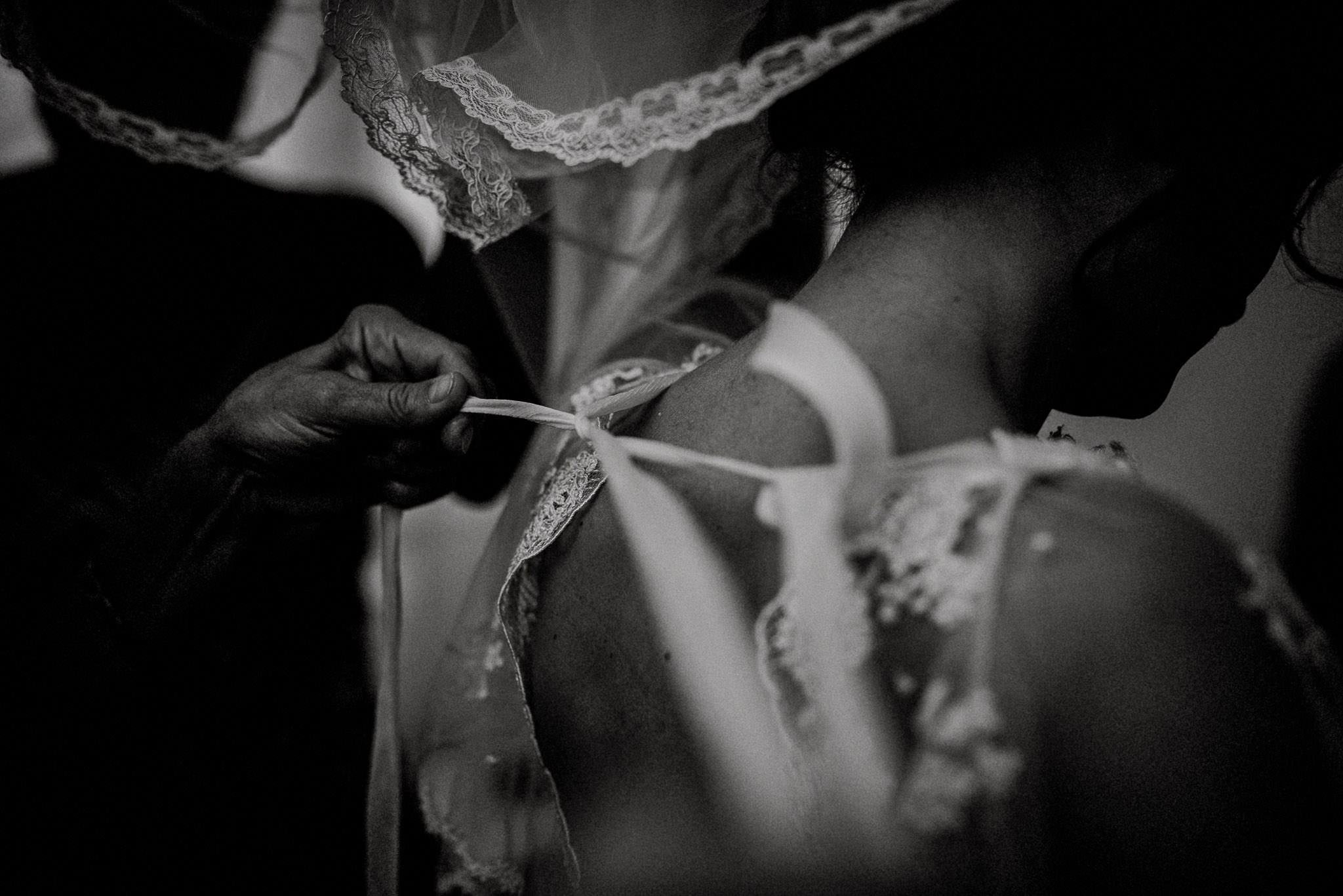 detail shot with bride putting on her wedding dress