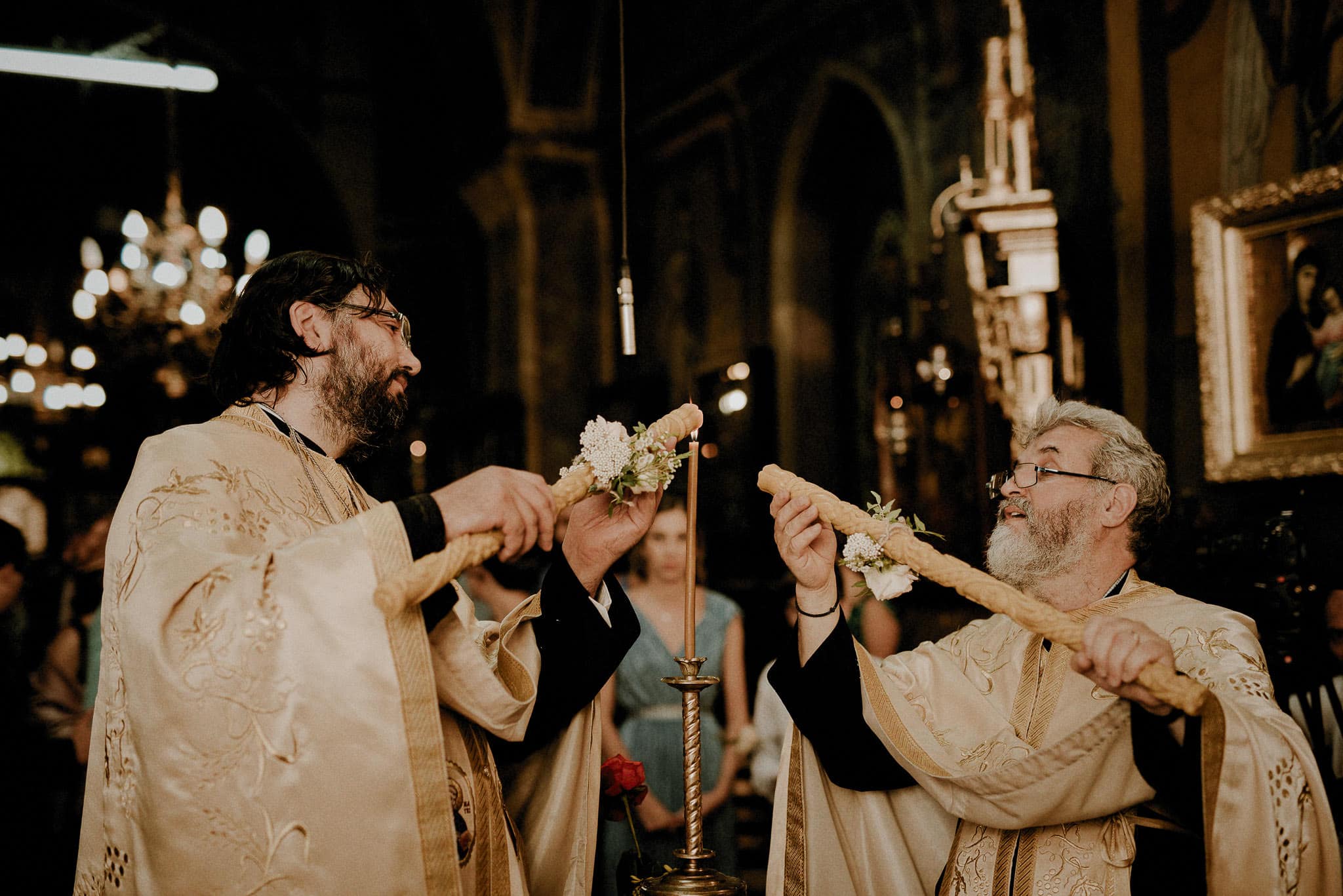priests light the candles inside the church as the religious wedding ceremony begins
