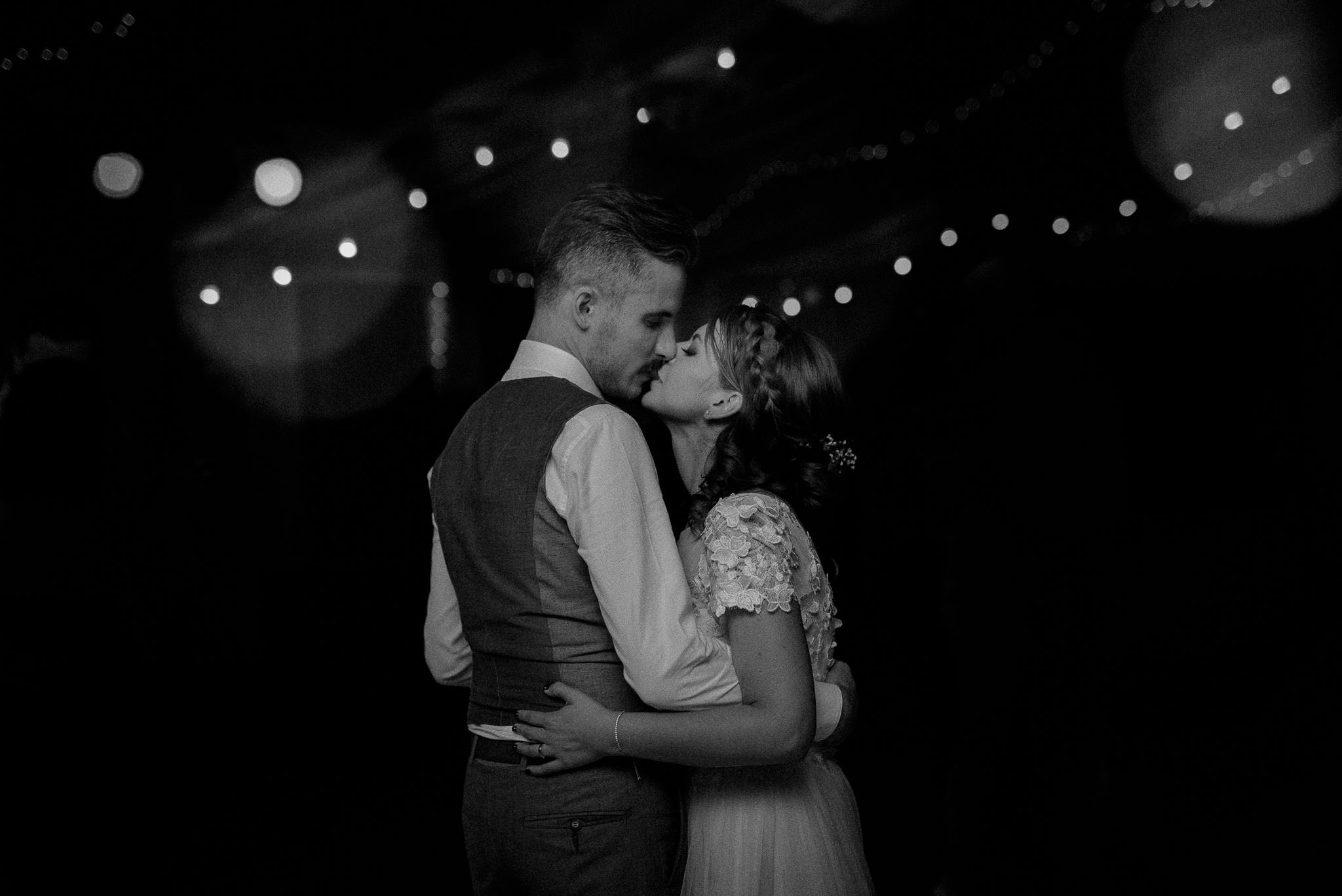 bride and groom share a romantic kiss on the dance floor