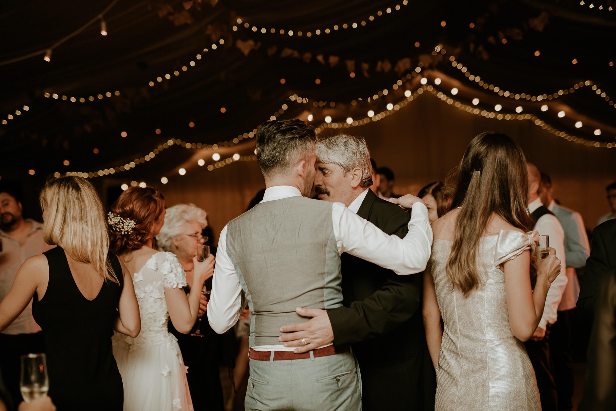 groom gets congratulated by his father