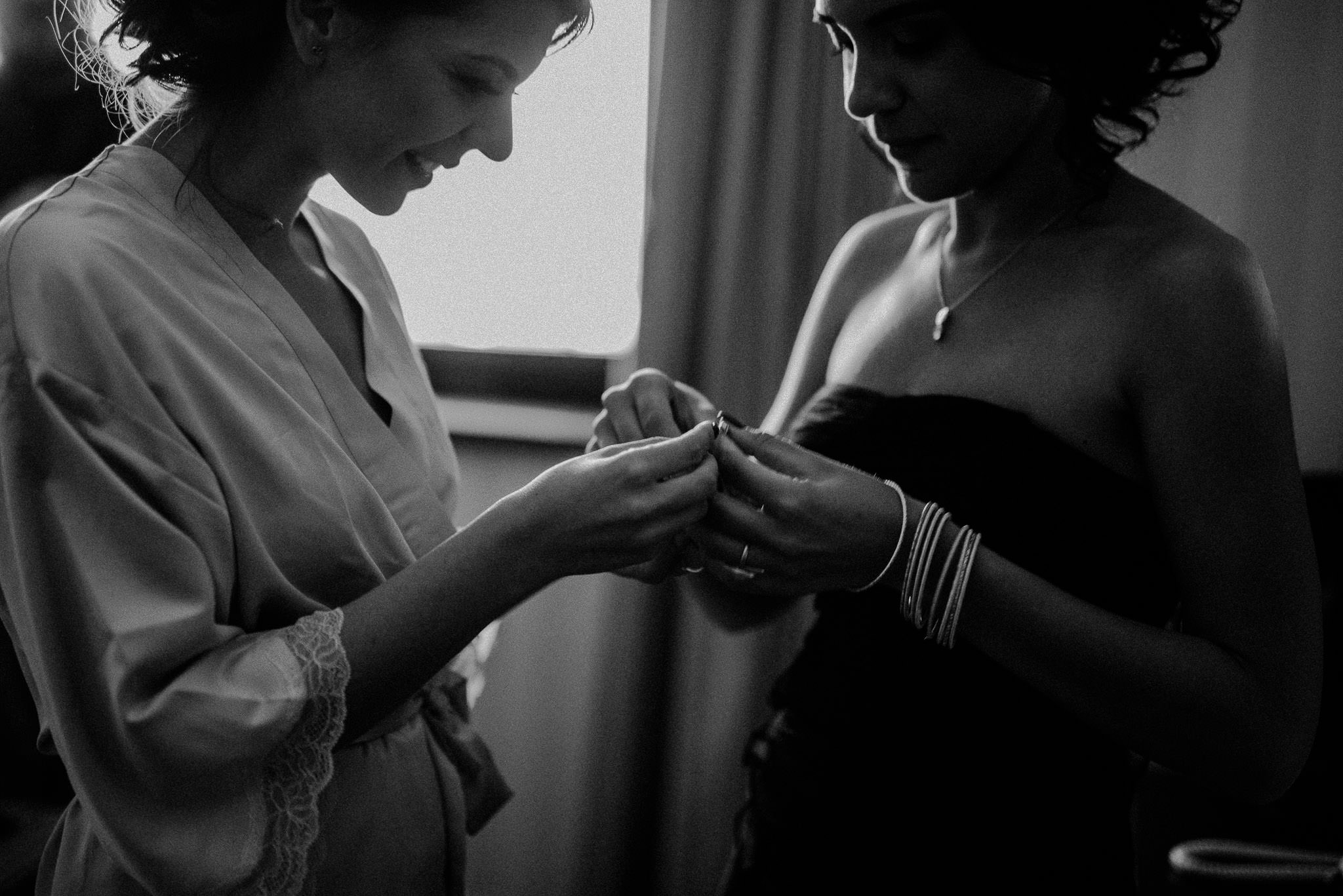 bride receiving present from her bridesmaid