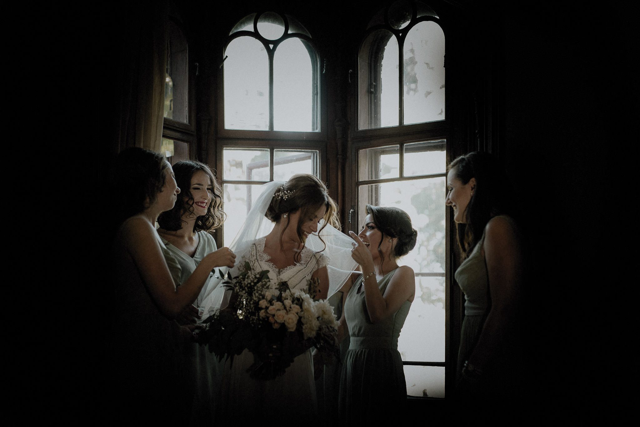bride getting ready before her wedding surrounded by her bridesmaids