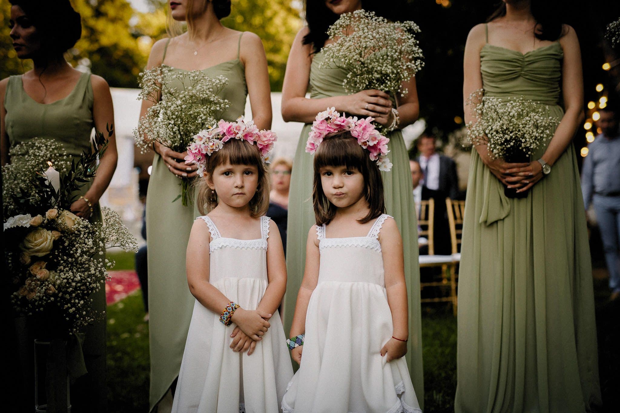 flower girls are waiting for the outdoor wedding ceremony to begin