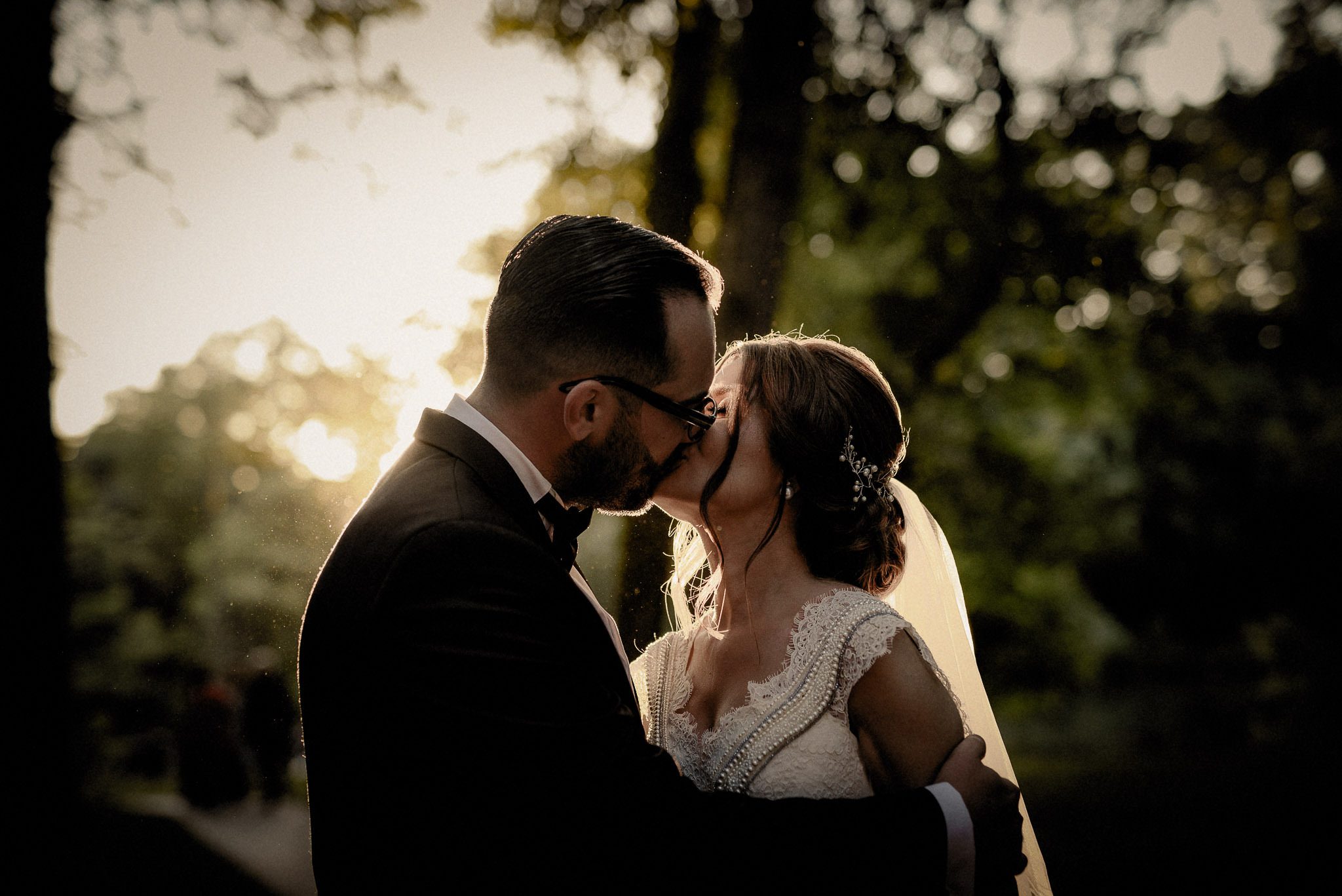 bride and groom share a romantic sunset kiss