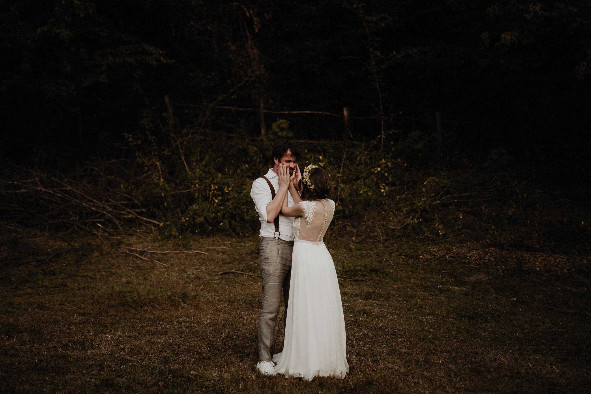 romantic moment between bride and groom in the forest