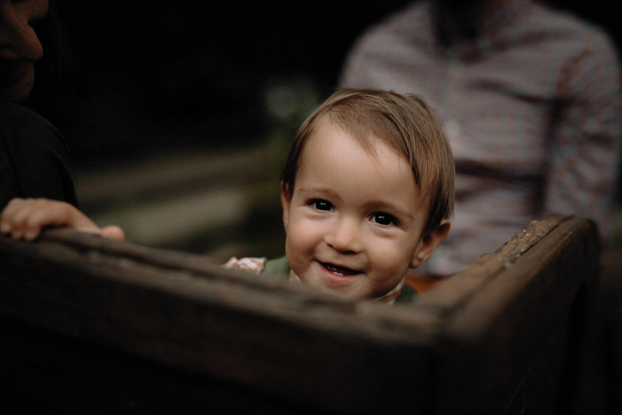 little boy laughing during the outdoor traditional wedding in the forest