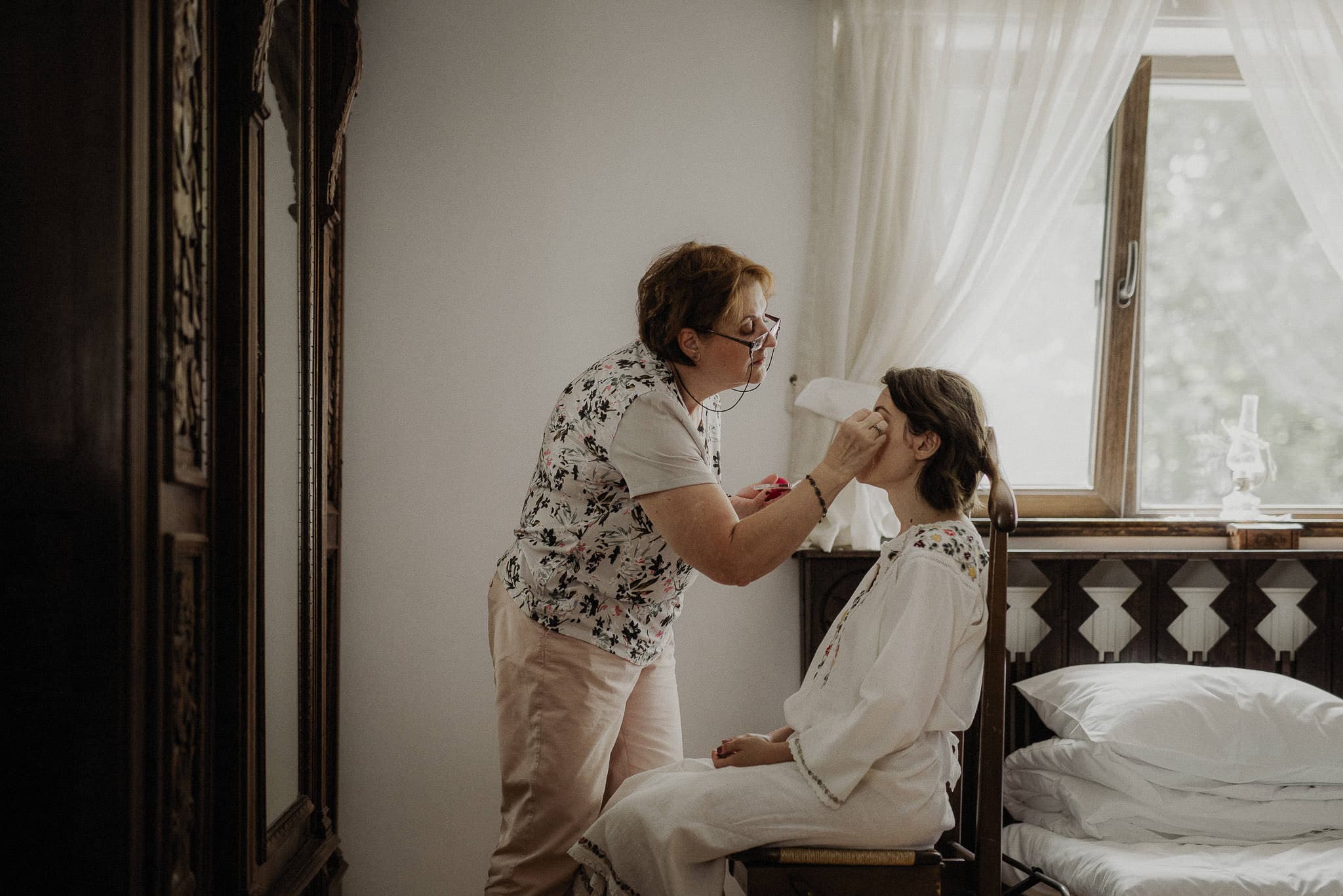 mother of the bride doing the bride's makeup
