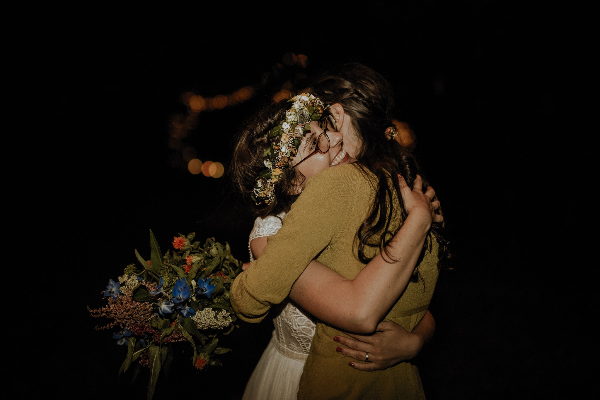 bride hugging the girl who caught the bouquet during outdoor forest wedding