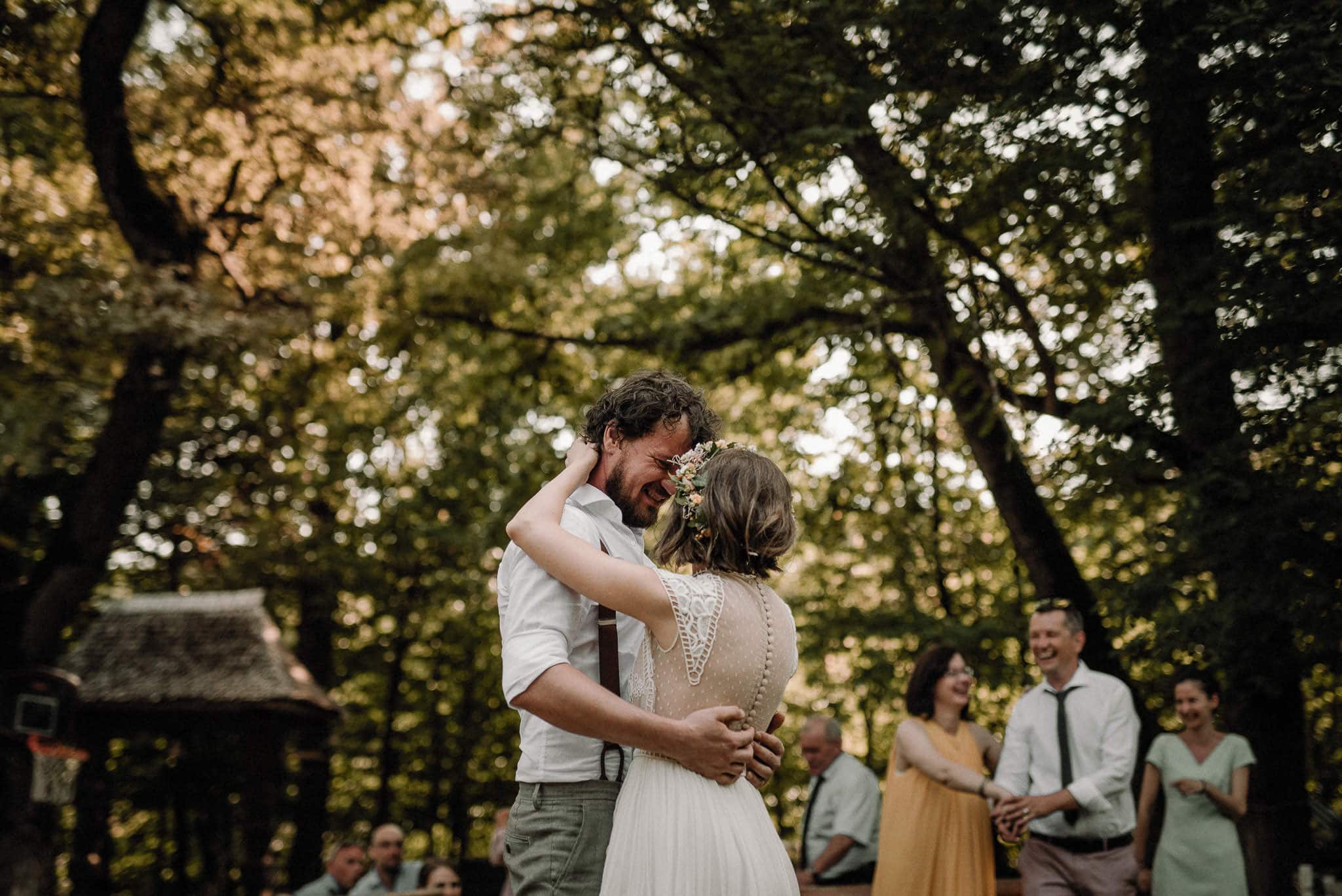 bride and groom share their first dance in the forest