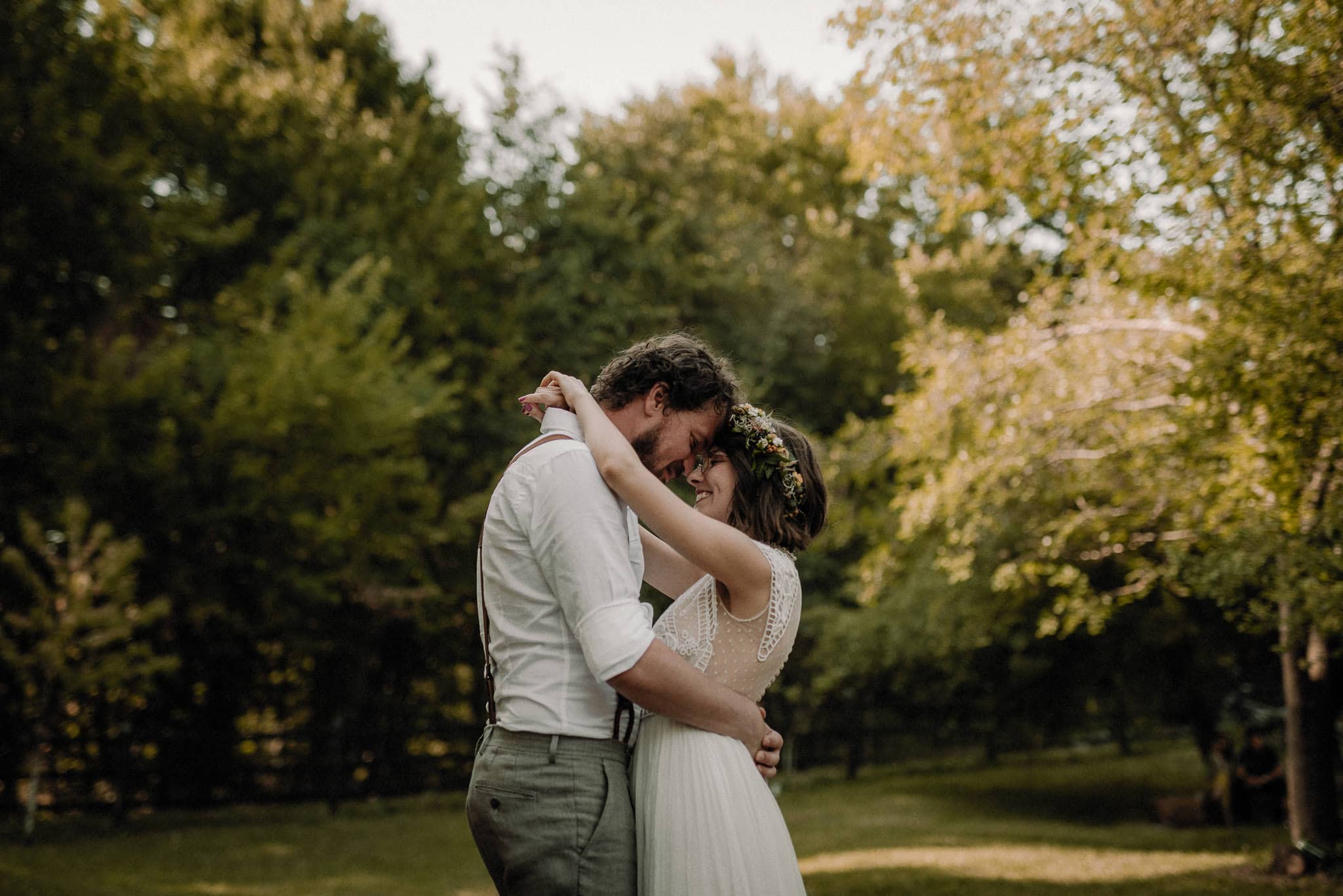 bride and groom share their first dance in the forest