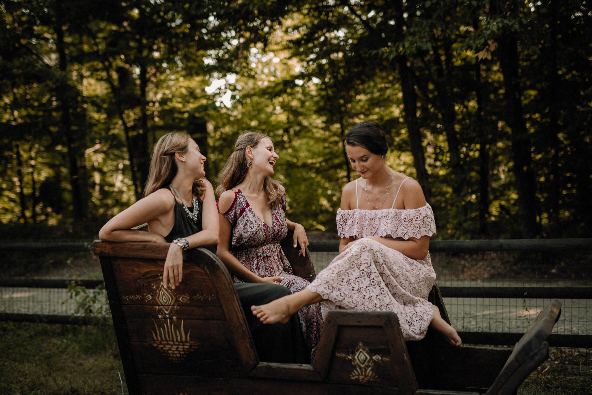 relaxed bridesmaids on an old wooden cart