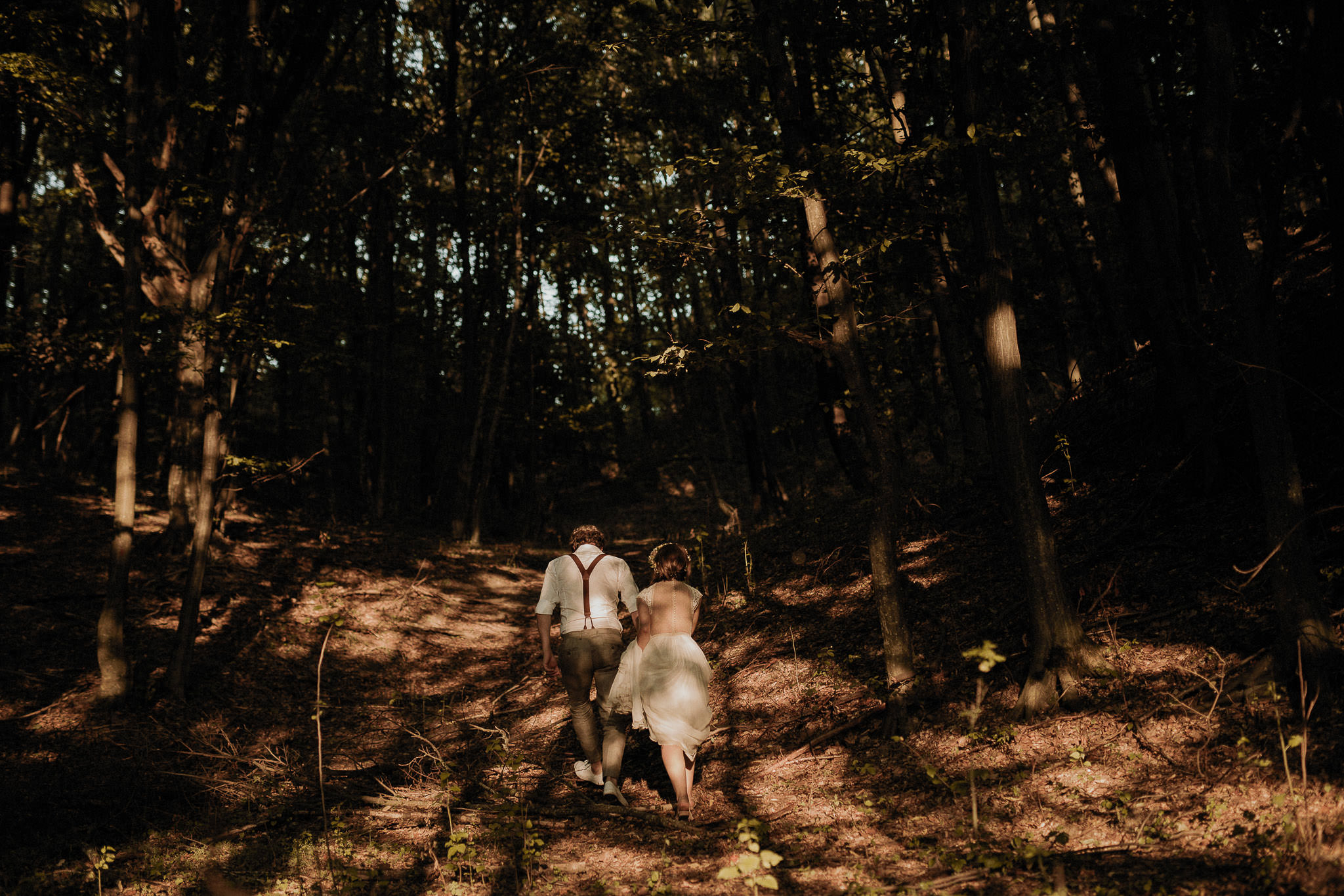 bride and groom walking in the forest