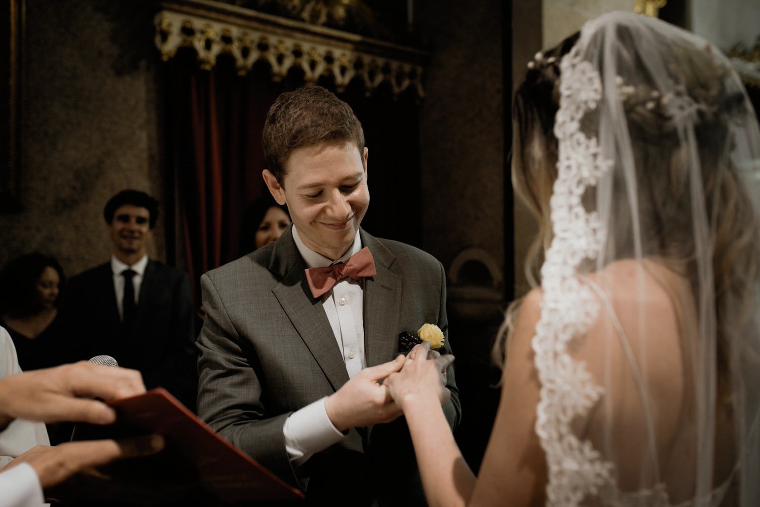 emotional groom putting the wedding ring on his bride's finger