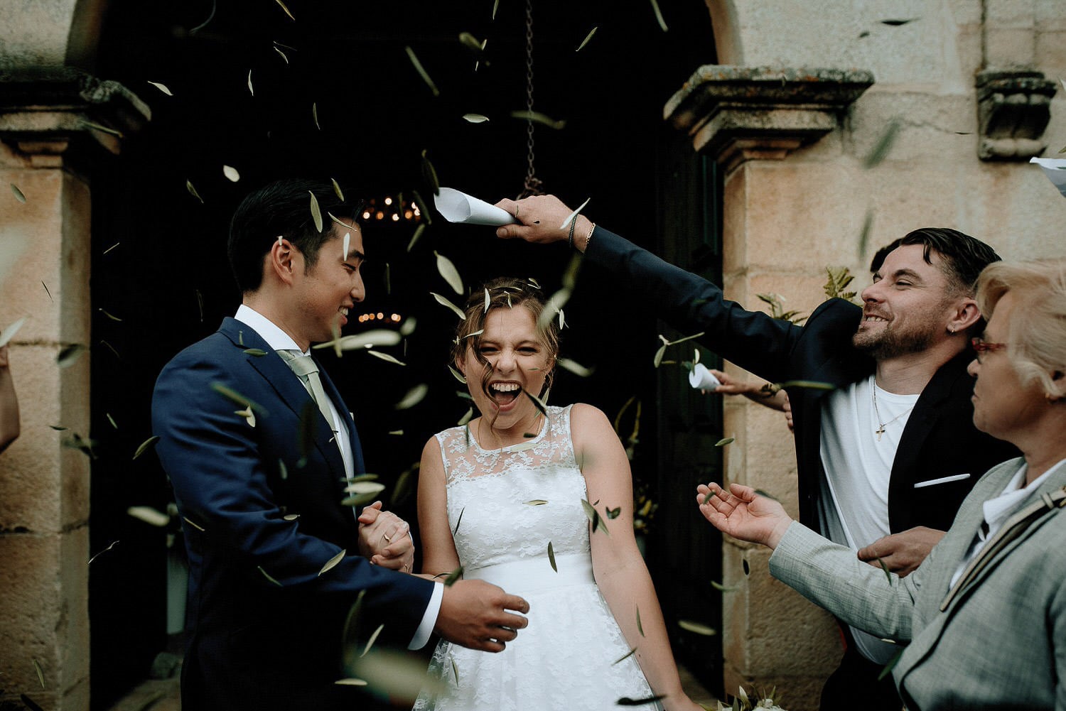 Charming Destination Wedding in the Portuguese Countryside - bride and groom church exit with olive tree leaves