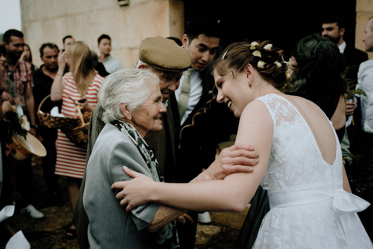 Charming Destination Wedding in the Portuguese Countryside - bride sharing an emotional moment with her grandparents in front of the same church they got married in