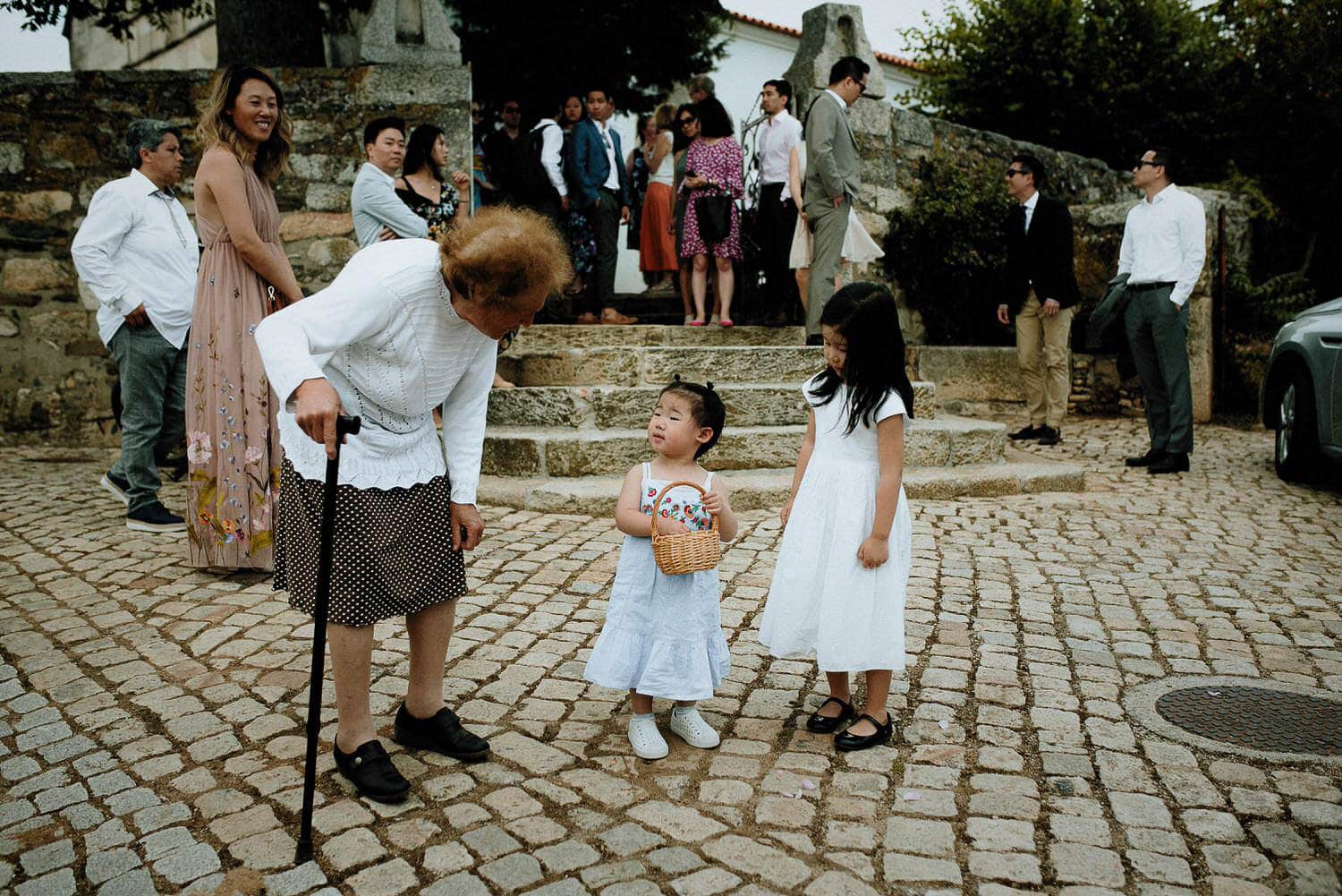 Charming Destination Wedding in the Portuguese Countryside - older woman talking to two young asian girls