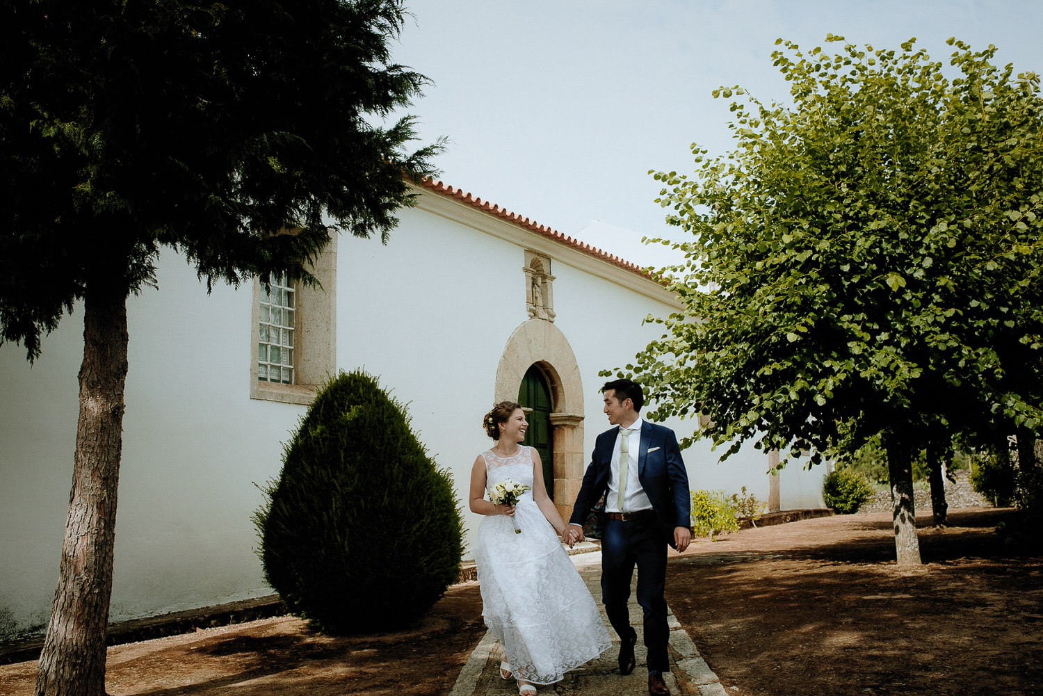Charming Destination Wedding in the Portuguese Countryside - bride and groom just married walking down from church