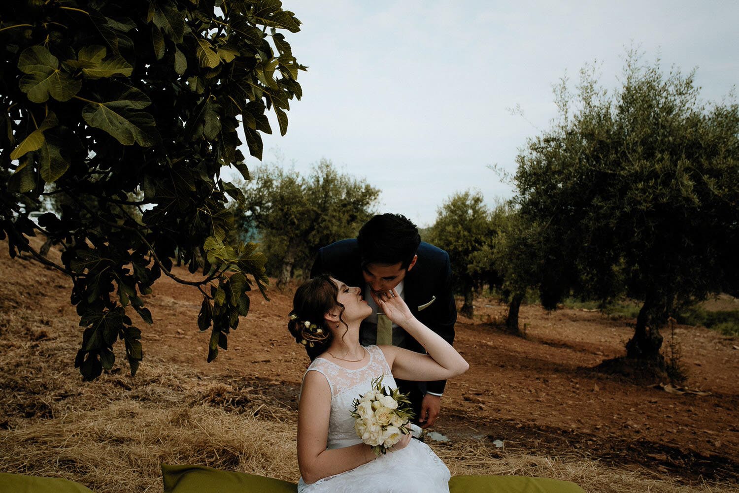 Charming Destination Wedding in the Portuguese Countryside - bride and groom kissing surrounded by olive trees