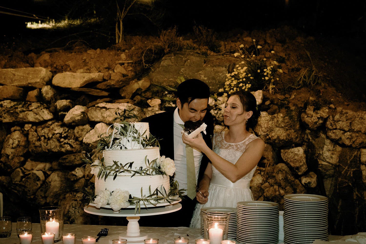 Charming Destination Wedding in the Portuguese Countryside - groom taking a big bite of the wedding cake